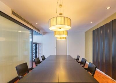 Spacious modern meeting room with long table and hanging lights