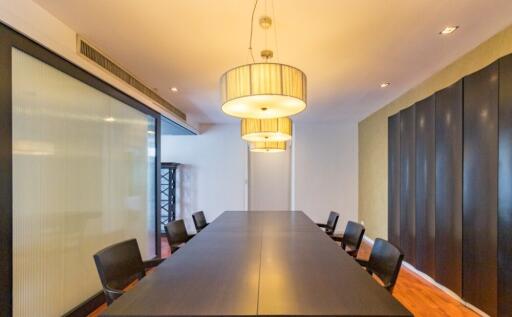 Spacious modern meeting room with long table and hanging lights