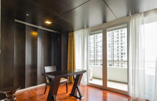 Modern bedroom with a table and city view balcony