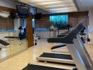 well-equipped gym with treadmills and large mirrors