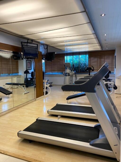 well-equipped gym with treadmills and large mirrors