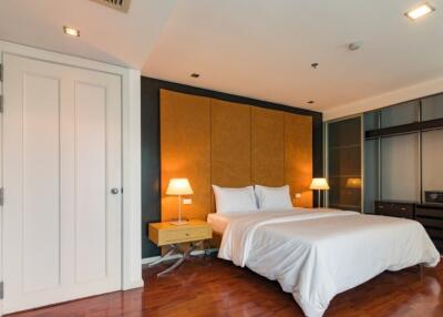 Modern bedroom with hardwood floors, a double bed, and ambient lighting