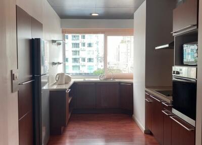 Modern kitchen with wooden floors and stainless steel appliances