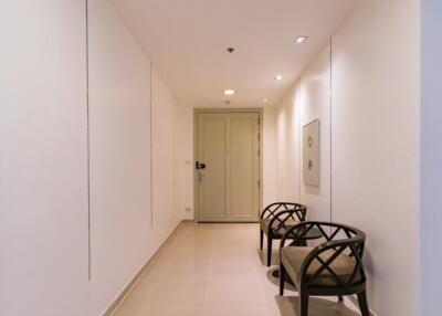 Well-lit hallway with two chairs and elegant decor