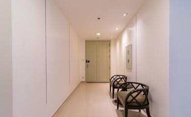 Well-lit hallway with two chairs and elegant decor