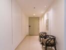 Well-lit hallway with two chairs and elegant decor