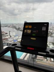 View from a treadmill in a gym with a river and cityscape in the background