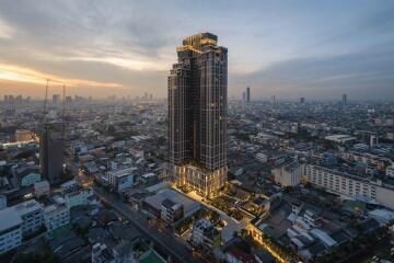 Aerial view of a tall building in a cityscape at dusk