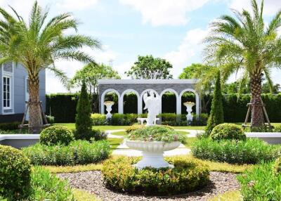 Beautifully landscaped garden with palm trees and statues