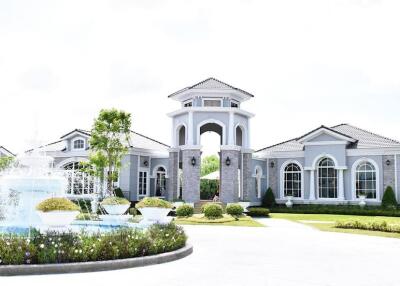 Exterior view of a large house with a fountain