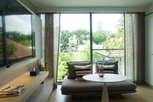 Cozy living room with large window and greenery view