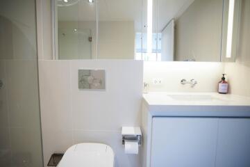 Modern bathroom with white fixtures and glass shower