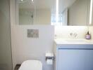 Modern bathroom with white fixtures and glass shower