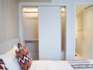 A modern bedroom with an open closet and a partial view of an adjoining bathroom