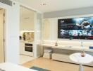 Modern living area with wall-mounted TV and open plan kitchen