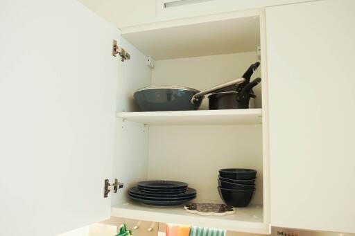 Open kitchen cabinet with dishes and pans