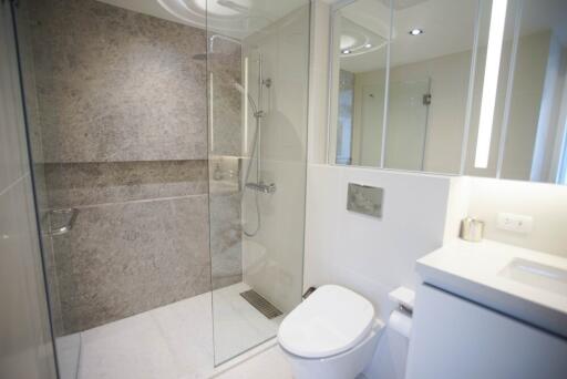 Modern bathroom with glass-enclosed shower and white fixtures