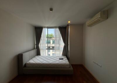 Simple bedroom with bed near window and air conditioner