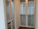 spacious closet with wooden floor and glass doors