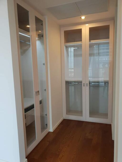 spacious closet with wooden floor and glass doors