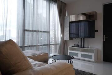 Modern living room with large windows and a mounted TV