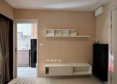 Living room with minimalist decor and view into kitchen