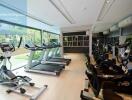 Well-equipped gym with modern exercise machines and large windows