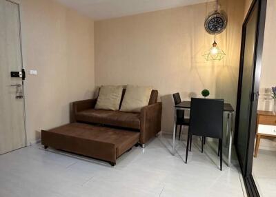 Cozy living room with a brown sofa and dining area