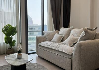 living room with sofa, coffee table, and large window