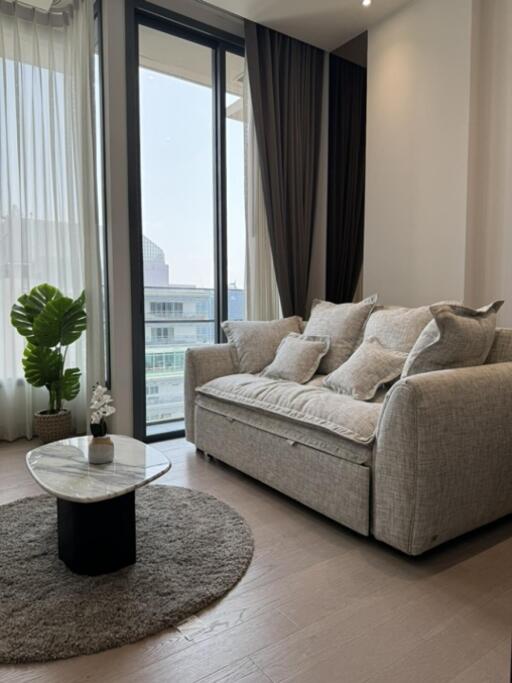 living room with sofa, coffee table, and large window