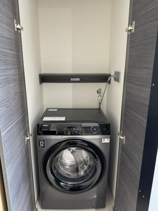 Compact laundry area with washer and shelf