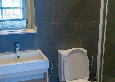 Modern bathroom with toilet, sink, and shower