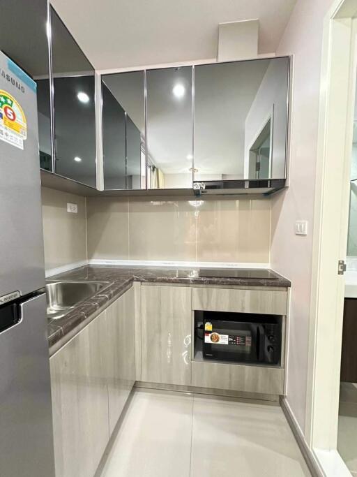 Modern kitchen with stainless steel appliances and reflective cabinetry