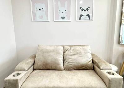 Beige sofa with cup holders and cute animal wall art