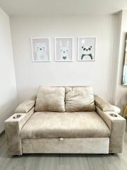 Beige sofa with cup holders and cute animal wall art