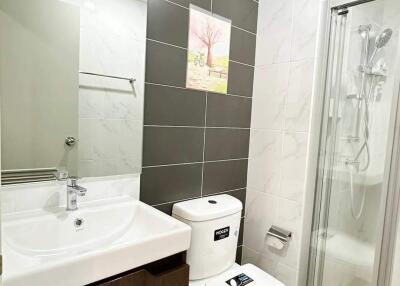 Modern bathroom with white fixtures and dark accent tiles