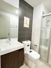 Modern bathroom with white fixtures and dark accent tiles