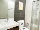 Modern bathroom with white fixtures and dark accent tiles