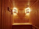 Wood-paneled sauna with built-in wooden benches and warm lighting