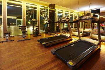 Modern gym with large windows and various fitness equipment