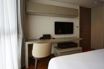 Modern bedroom with a desk and TV