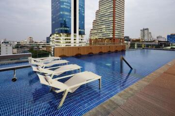 rooftop swimming pool with lounge chairs and city view