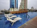 rooftop swimming pool with lounge chairs and city view