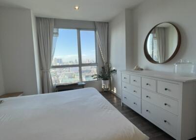 Modern bedroom with large window and dresser