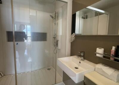 Modern bathroom with glass shower enclosure, sink, and mirror