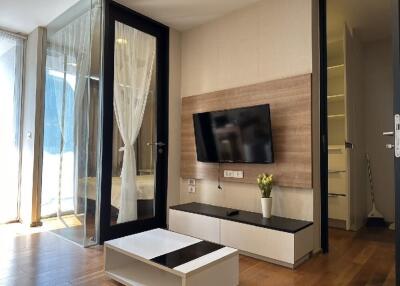 Modern living room with a wall-mounted TV and simple furnishings