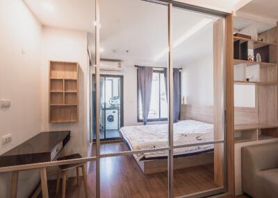 Bedroom with sliding glass doors, bed, desk, and shelving unit