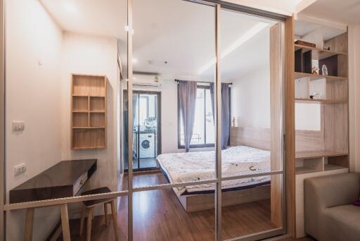 Bedroom with sliding glass doors, bed, desk, and shelving unit