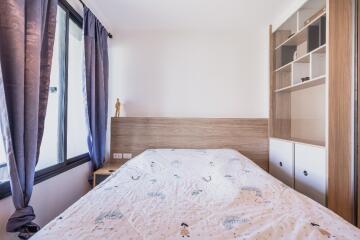 Bright bedroom with large window and shelving unit