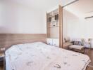 Bright bedroom with white bedding and wooden accents leading to a living area